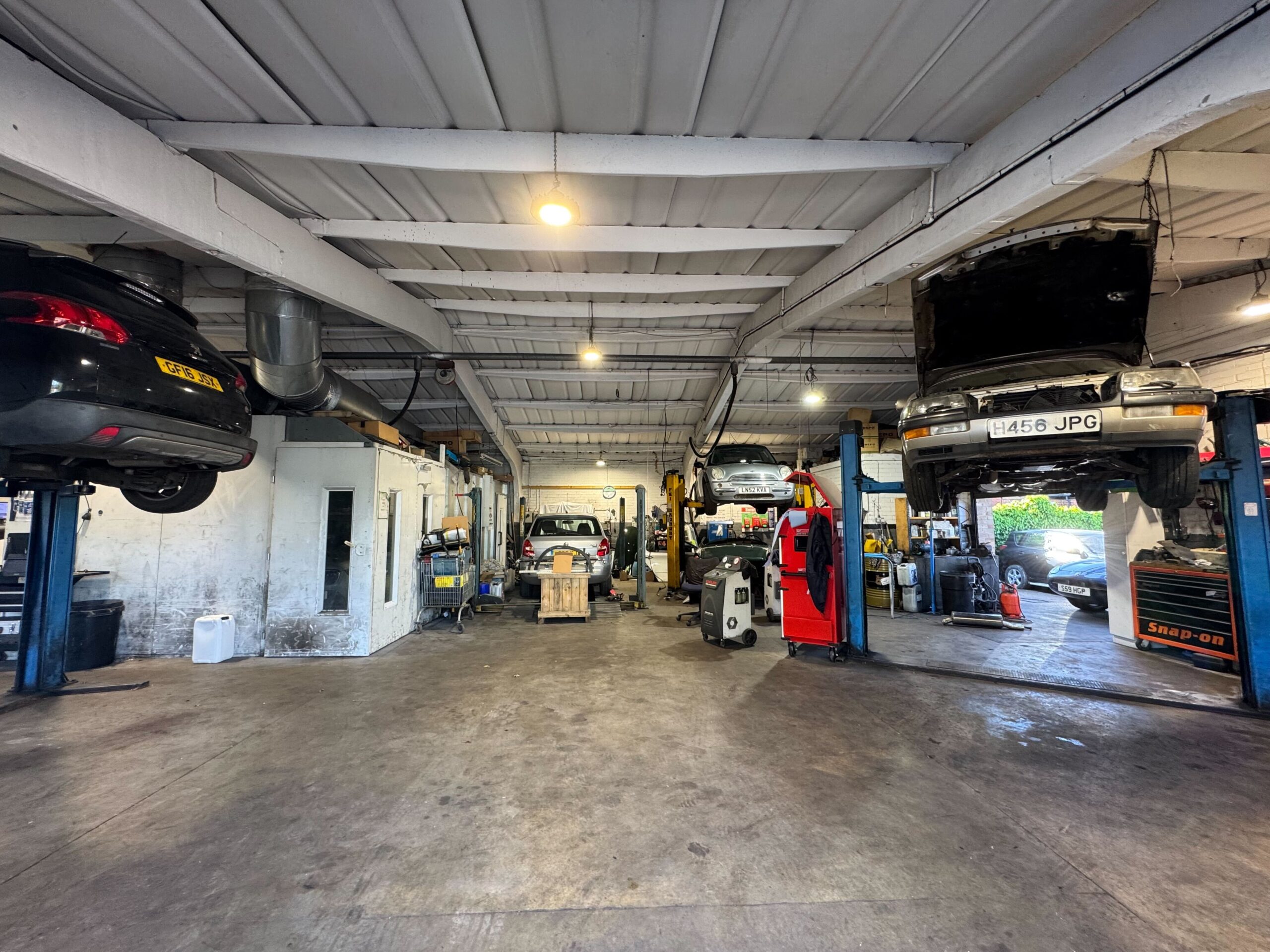 Inside the Courtwood Car Services workshop in Uxbridge with several vehicles on lifts