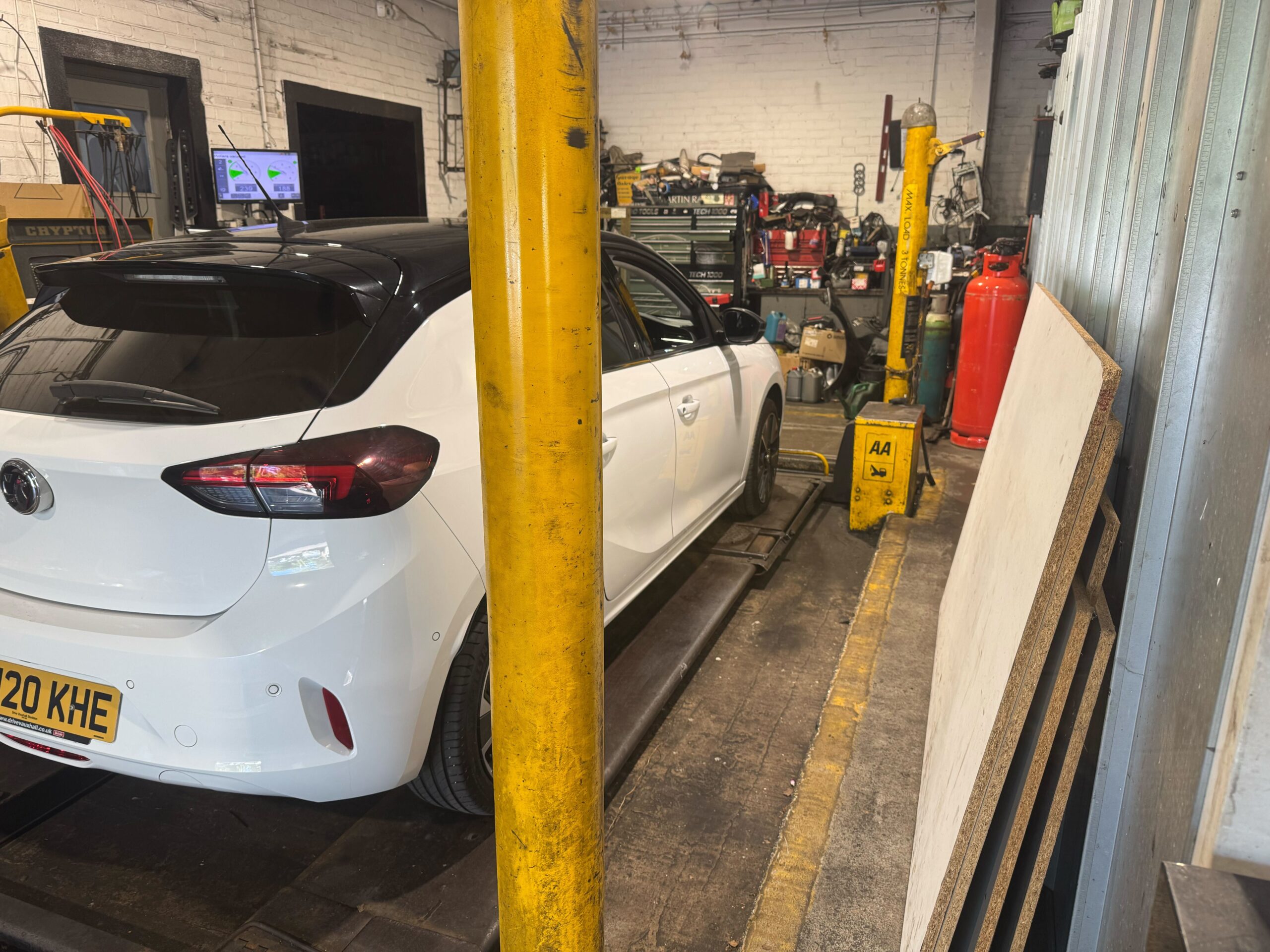 Car raised on an inspection ramp during an MOT test at Courtwood Car Services Uxbridge