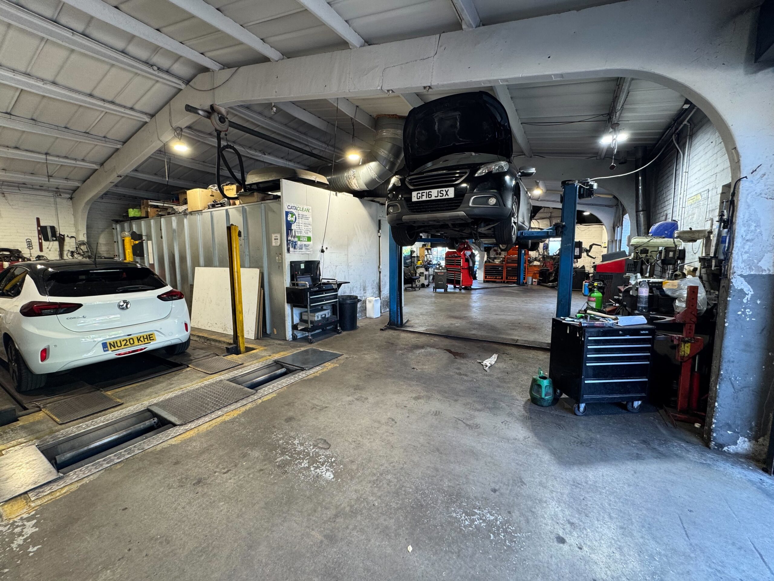 Volkswagen Crafter fleet van raised on a workshop lift for MOT at Courtwood Car Services Uxbridge